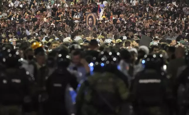 Serbian gendarmerie officers guard a street during an anti-government protest near the Serbian Progressive Party office in Belgrade, Serbia, Friday, Aug. 15, 2025. (AP Photo/Darko Vojinovic)