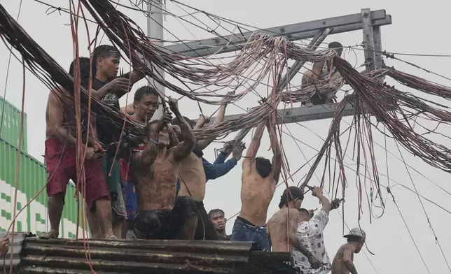 Residents salvage electrical wire for selling, after a massive fire broke out in the residential area of Manila, Philippines, Aug. 6, 2025. (AP Photo/Aaron Favila)