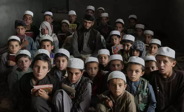 Students pose for a group photo with their teacher during a Quran class at the Abdullah Ibn-Masoud religious school, on the outskirts of Kabul, Afghanistan, May 26, 2025. (AP Photo/Ebrahim Noroozi)