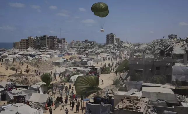 Palestinians rush to collect humanitarian aid airdropped by parachutes into Gaza City, northern Gaza Strip, Aug. 7, 2025. (AP Photo/Jehad Alshrafi)