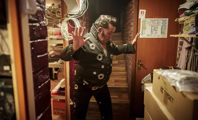 Tudor Lakatos, who goes by the stage name Elvis Rromano, strikes a pose while getting ready for his performance with the Taraful Frunzelor band at the Terasa Florilor restaurant, in Bucharest, Romania, June 20, 2025. (AP Photo/Vadim Ghirda)