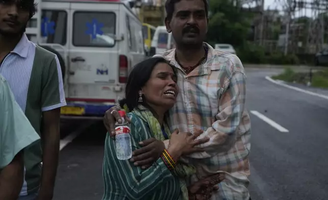 A pilgrim couple mourns the death of family members following a landslide due to floods on the route to the Shri Mata Vaishno Devi Temple, at the Government Medical Hospital in Jammu, India, Wednesday, Aug. 27, 2025. (AP Photo/Channi Anand)