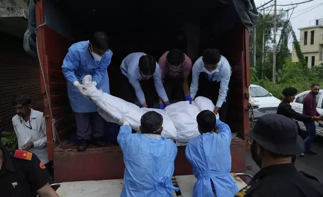 Health workers carry the body of a pilgrim who died in a landslide due to floods on the route to the Shri Mata Vaishno Devi Temple, being shifted to the Government Medical Hospital in Jammu, India, Wednesday, Aug. 27, 2025.(AP Photo/Channi Anand)