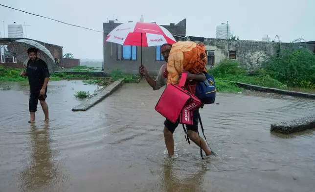 People leave their homes and move to safer places after River Tawi started overflowing due to heavy rain Jammu, India, Tuesday, Aug. 26, 2025.(AP Photo/Channi Anand)