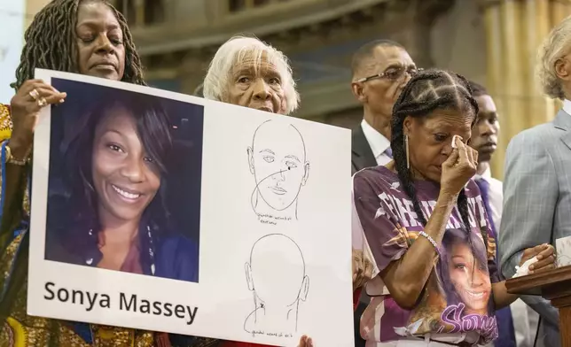 FILE - Donna Massey, center right, wipes tears from her face as she listens to Rev. Al Sharpton, right, speak during a press conference Tuesday, July 30, 2024, in Chicago, over the shooting death of her daughter Sonya, who was allegedly killed by Illinois sheriff's deputy Sean Grayson. (Tyler Pasciak LaRiviere/Chicago Sun-Times via AP)