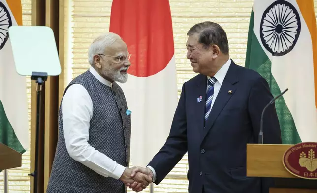India's Prime Minister Narendra Modi, left, and Japan's Prime Minister Shigeru Ishiba shake hands during a joint press conference in Tokyo, Japan, Aug. 29, 2025. (Takashi Aoyama/Pool Photo via AP)