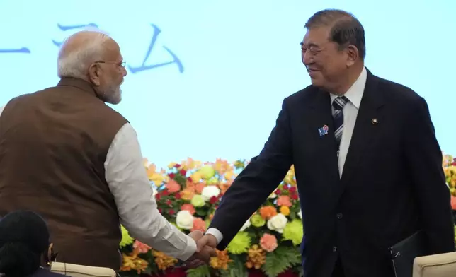 Indian Prime Minister Narendra Modi, left, and Japanese Prime Minister Shigeru Ishiba shake hands during the Japan India Economic Forum in Tokyo Friday, Aug. 29, 2025. (AP Photo/Eugene Hoshiko)