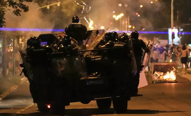 Serbian gendarmerie officers chase protesters during an anti-government protest in Belgrade, Serbia, Monday, Aug. 18, 2025. (AP Photo/Darko Vojinovic)