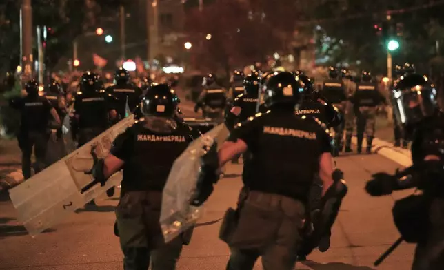 Serbian gendarmerie officers chase protesters during an anti-government protest in Belgrade, Serbia, Monday, Aug. 18, 2025. (AP Photo/Darko Vojinovic)