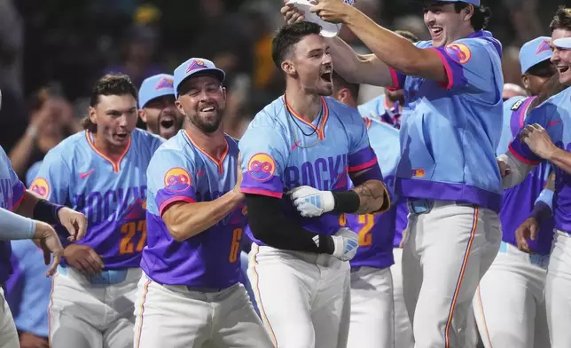 Colorado Rockies' Brenton Doyle, third from left, celebrates after hitting a two-run, walkoff home run with teammates, from left, Jordan Beck, Kyle Farmer and Michael Toglia in the ninth inning of a baseball game against the Pittsburgh Pirates Friday, Aug. 1, 2025, in Denver. (AP Photo/David Zalubowski)