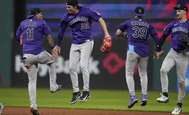 Colorado Rockies' Orlando Arcia (11), Mickey Moniak (22), Thairo Estrada (39) and Brenton Doyle, right, celebrate after the Rockies defeated the Cleveland Guardians in a baseball game in Cleveland, Tuesday, July 29, 2025. (AP Photo/Sue Ogrocki)