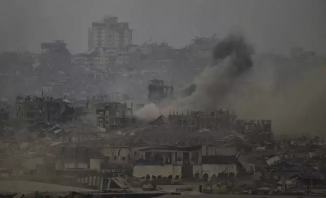Smoke rises amid destroyed buildings following an Israeli shelling in the Gaza Strip, as seen from southern Israel, Friday, Aug. 1, 2025. (AP Photo/Leo Correa)