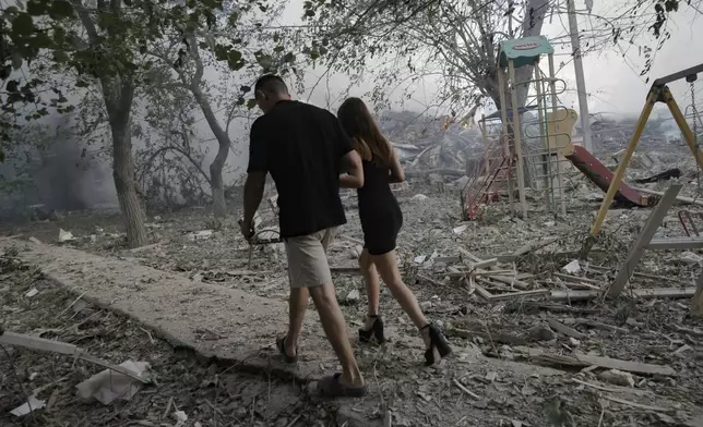 Residents pass by the site of the Russian air strike which destroyed a residential house in Kramatorsk, Ukraine, on Thursday, July 31, 2025. (AP Photo/Yevhen Titov)