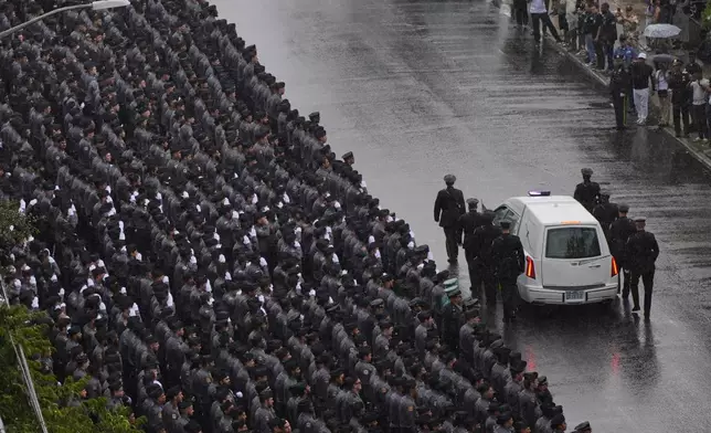 New York Police officers salute as the hearse carrying the casket of NYPD officer Didarul Islam passes after his funeral, Thursday, July 31, 2025, in New York. (AP Photo/Yuki Iwamura )