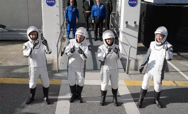 Astronauts, from left, Oleg Platonov, of Russia, Mike Fincke, Zena Cardman, and Kimiya Yui, of Japan, pose for a photo as they leave the Operations and Checkout Building for a trip the Kennedy Space Center's Launch Pad 39-A and a planned liftoff on a SpaceX Falcon 9 rocket Friday, Aug. 1, 2025, in Cape Canaveral , Fla. (AP Photo/John Raoux)