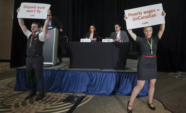 Air Canada executives are interrupted by Air Canada flight attendants during a news conference as a possible strike looms, in Toronto, on Thursday, Aug. 14, 2025. (Nathan Denette/The Canadian Press via AP)