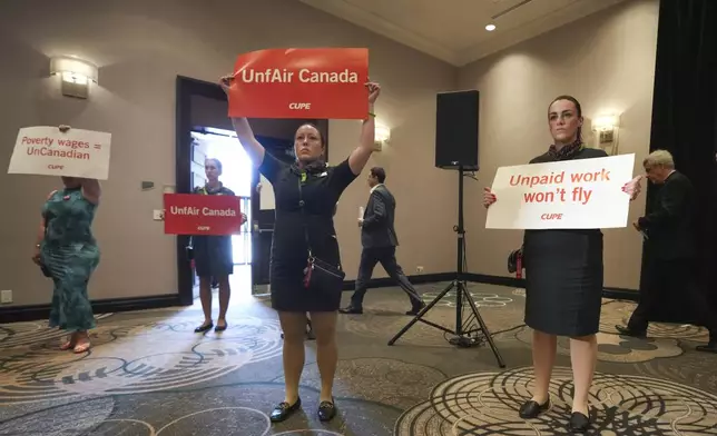Air Canada executives leave after they are interrupted by Air Canada flight attendants during a press conference as a possible strike looms, in Toronto, on Thursday, Aug. 14, 2025. (Nathan Denette/The Canadian Press via AP)