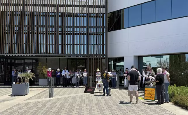 About 25 people gather for a prayer vigil for immigrants outside Santa Ana Immigration Court in Santa Ana, Calif., Thursday, July 31, 2025. (AP Photo/Deepa Bharath)