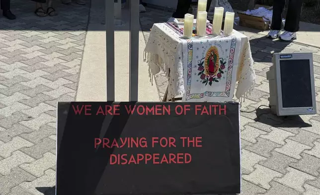 A sign and a shrine bearing the image of Our Lady of Guadalupe are placed outside Santa Ana Immigration Court during a prayer vigil for immigrants in Santa Ana, Calif., Thursday, July 31, 2025. (AP Photo/Deepa Bharath)