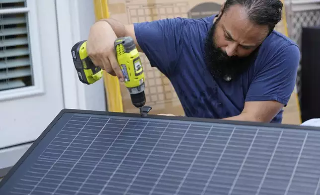 Bhavin Misra assembles a Craftstrom Solar plug-in kit at his home Tuesday, Aug. 5, 2025, in Houston. (AP Photo/David J. Phillip)
