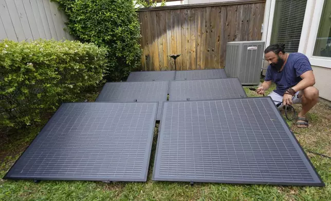 Bhavin Misra assembles a Craftstrom Solar plug-in kit at his home Tuesday, Aug. 5, 2025, in Houston. (AP Photo/David J. Phillip)