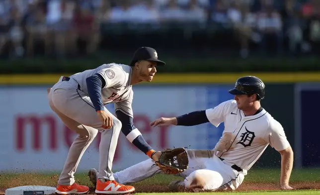 Detroit Tigers' Colt Keith, right, slides against Houston Astros shortstop Jeremy Pena, left, to steal second base during the first inning of a baseball game, Monday, Aug. 18, 2025, in Detroit. (AP Photo/Ryan Sun)