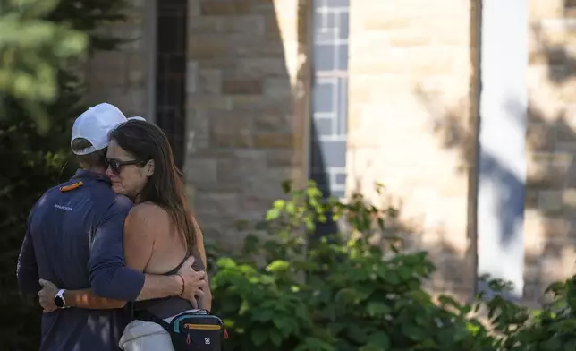 Kristen Neville and Michael Burt embrace each other at Annunciation Catholic Church after Wednesday's school shooting, Thursday, Aug. 28, 2025, in Minneapolis. (AP Photo/Abbie Parr)