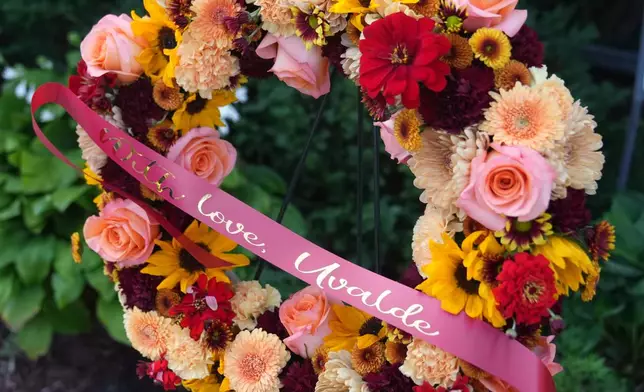 A wreath of flowers is left on behalf of families of victims of the Robb Elementary School school shootings in Uvalde, Texas at Annunciation Catholic Church after Wednesday's school shooting, Thursday, Aug. 28, 2025, in Minneapolis. (AP Photo/Abbie Parr)