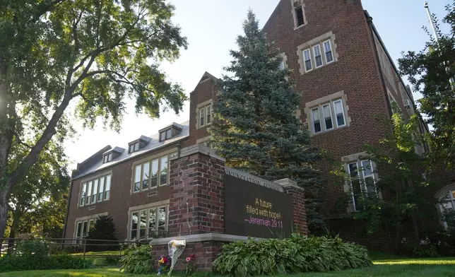 Flowers are placed near the Annunciation Catholic School after Wednesday's school shooting, Thursday, Aug. 28, 2025, in Minneapolis. (AP Photo/Abbie Parr)