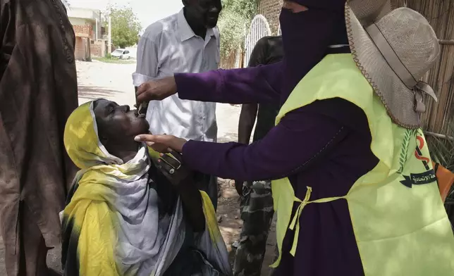 A health worker administers an oral cholera vaccine to a woman during a 10-day vaccination campaign in Khartoum, Sudan, Wednesday, Aug. 13, 2025. (AP Photo/Marwan Ali)