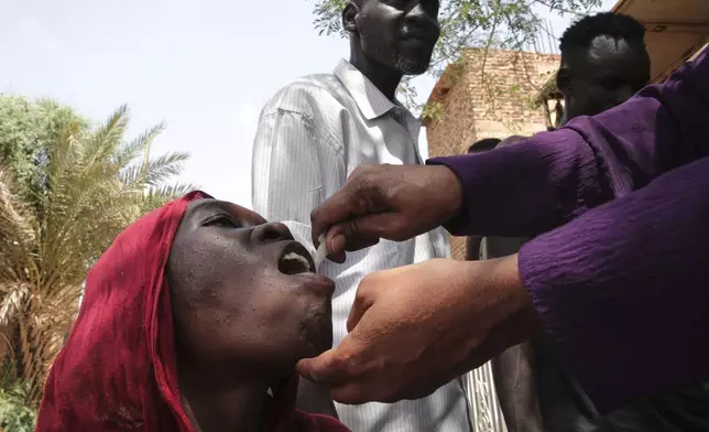 A Sudanese woman receives an oral cholera vaccine during a 10-day vaccination campaign conducted by health ministry workers in Khartoum, Sudan, Wednesday, Aug. 13, 2025. (AP Photo/Marwan Ali)