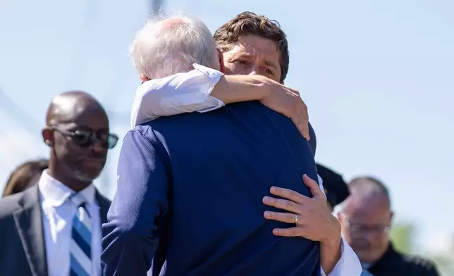 Minnesota Governor Tim Walz, front, embraces Minneapolis Mayor Jacob Frey before a press conference outside Annunciation Church after a shooting earlier on Wednesday, Aug. 27, 2025, in Minneapolis. (Alex Kormann/Star Tribune via AP)