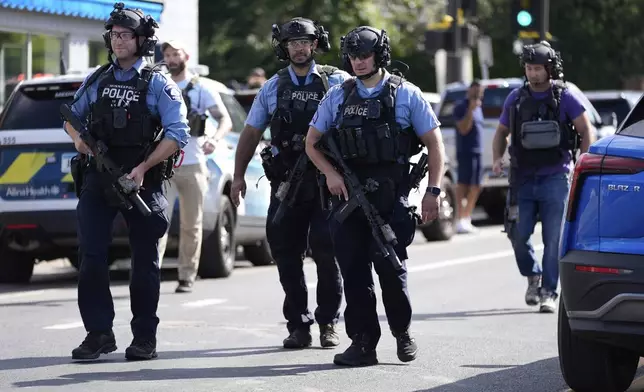Law enforcement officers gather outside the Annunciation Church's school in response to a reported mass shooting, Wednesday, Aug. 27, 2025, in Minneapolis. (AP Photo/Abbie Parr)