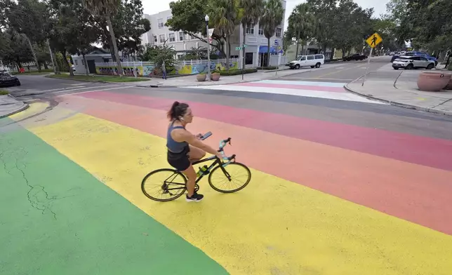 A cyclist crosses a rainbow-painted street mural Wednesday, Aug. 27, 2025, in St. Petersburg, Fla. (AP Photo/Chris O'Meara)