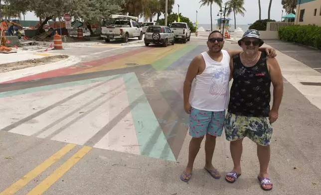 South Florida residents Jay Fuertes, left, and Jason Osborne pose in front of a rainbow-colored crosswalk celebrating gay rights and LGBTQ+ pride located a block from the beach on Aug. 27, 2025, in Fort Lauderdale, Fla. (AP Photo/Daniel Kozin)