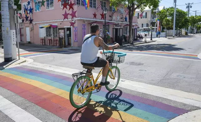 A bicyclist passes over a rainbow crosswalk on Duval Street in Key West, Fla., Tuesday, Aug. 26, 2025. (Rob O'Neal/The Key West Citizen via AP)