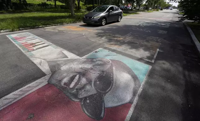 A motorist passes over a street mural outside the Dr. Carter G. Woodson African American Museum Wednesday, Aug. 27, 2025, in St. Petersburg, Fla. (AP Photo/Chris O'Meara)
