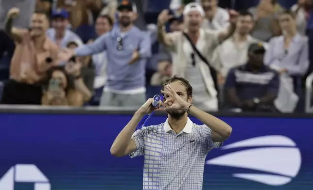 Fans react as Daniil Medvedev, of Russia, gestures after a photographer ran onto the court during a match against Benjamin Bonzi, of France, in the first-round of the U.S. Open tennis championships, Sunday, Aug. 24, 2025, in New York. (AP Photo/Adam Hunger)
