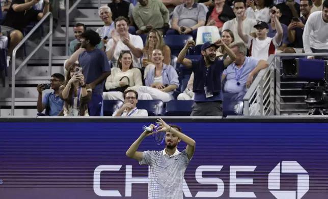 Fans react as Daniil Medvedev, of Russia, gestures after a photographer ran onto the court during a match against Benjamin Bonzi, of France, in the first-round of the U.S. Open tennis championships, Sunday, Aug. 24, 2025, in New York. (AP Photo/Adam Hunger)