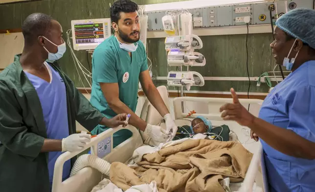 A doctor and staff members check on Anashe Mugoba as she recovers recovers from an open-heart surgery at Parirenyatwa Hospital, Harare, Zimbabwe, Thursday, July 17, 2025. (AP Photo/Aaron Ufumeli)