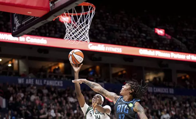 Seattle Storm's Dominique Malonga (14) lays up as Atlanta Dream's Brittney Griner (42) defends during the first half of a WNBA basketball game in Vancouver, British Columbia, on Friday, Aug. 15, 2025. (Ethan Cairns/The Canadian Press via AP)