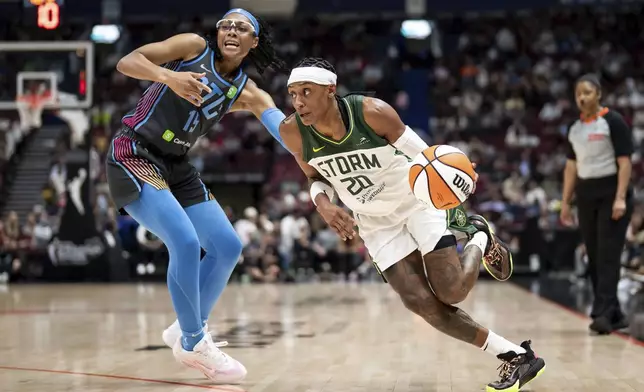 Seattle Storm's Brittney Sykes (20) drives past Atlanta Dream's Allisha Gray (15) during the first half of a WNBA basketball game in Vancouver, British Columbia, on Friday, Aug. 15, 2025. (Ethan Cairns/The Canadian Press via AP)