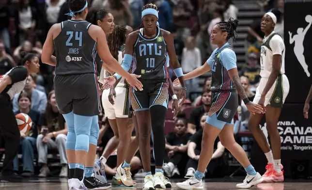 Atlanta Dream's Rhyne Howard (10) celebrates with teammates after scoring against the Seattle Storm during the first half of a WNBA basketball game in Vancouver, British Columbia, on Friday, Aug. 15, 2025. (Ethan Cairns/The Canadian Press via AP)