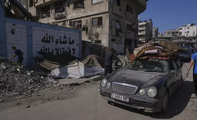 Displaced Palestinians fleeing northern Gaza Strip move with their belongings on a street in Gaza City, Thursday, Aug. 28, 2025. (AP Photo/Abdel Kareem Hana)