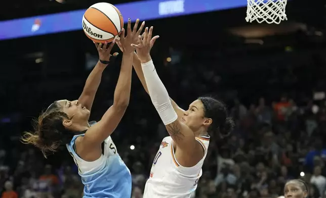 Chicago Sky forward Angel Reese, left, gets off a shot against Phoenix Mercury forward Satou Sabally (0) during the second half of a WNBA basketball game Thursday, Aug. 28, 2025, in Phoenix. (AP Photo/Ross D. Franklin)