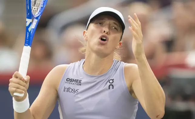 Iga Swiatek, of Poland, reacts during her match against Clara Tauson, of Denmark, during round of 16 action at the National Bank Open women's tennis tournament in Montreal, Sunday, Aug. 3, 2025. (Christinne Muschi/The Canadian Press via AP)