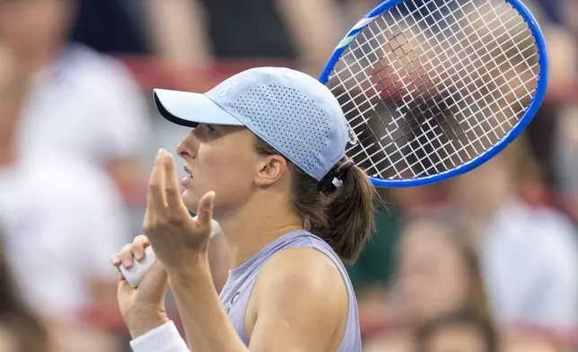 Iga Swiatek, of Poland, reacts during her match against Clara Tauson, of Denmark, during round of 16 action at the National Bank Open women's tennis tournament in Montreal, Sunday, Aug. 3, 2025. (Christinne Muschi/The Canadian Press via AP)