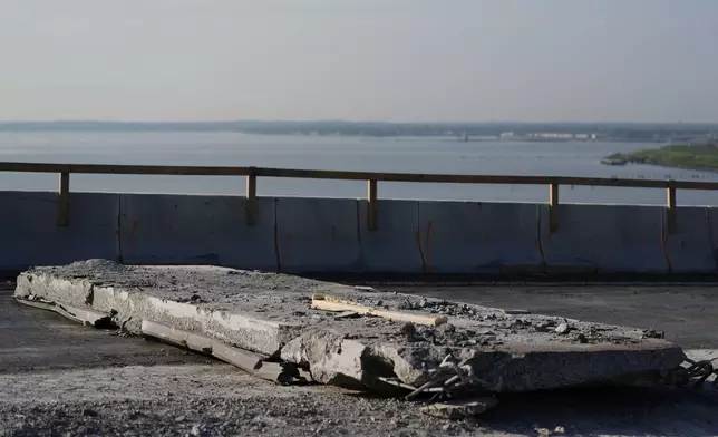 A slab of concrete is prepared to be removed from the remaining portions of the Francis Scott Key Bridge, Wednesday, July 30, 2025, in Baltimore. (AP Photo/Stephanie Scarbrough)