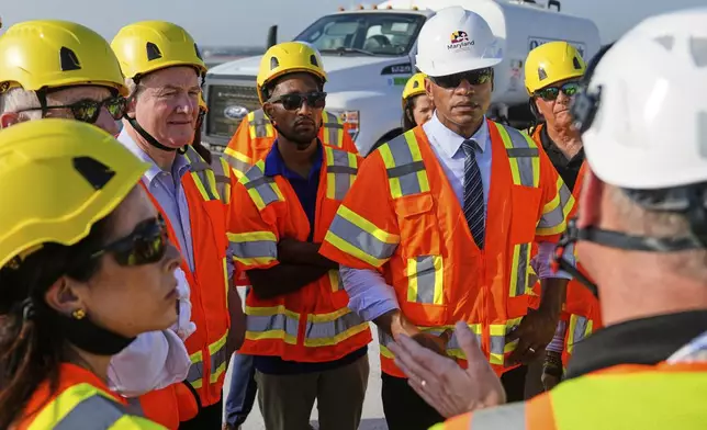 From center left, Sen. Chris Van Hollen, D-Md., Baltimore Mayor Brandon Scott and Maryland Gov. Wes Moore speak with representatives of the Maryland Transportation Authority during a tour of the demolition work zone for the remaining portions of the Francis Scott Key Bridge, Wednesday, July 30, 2025, in Baltimore. (AP Photo/Stephanie Scarbrough)