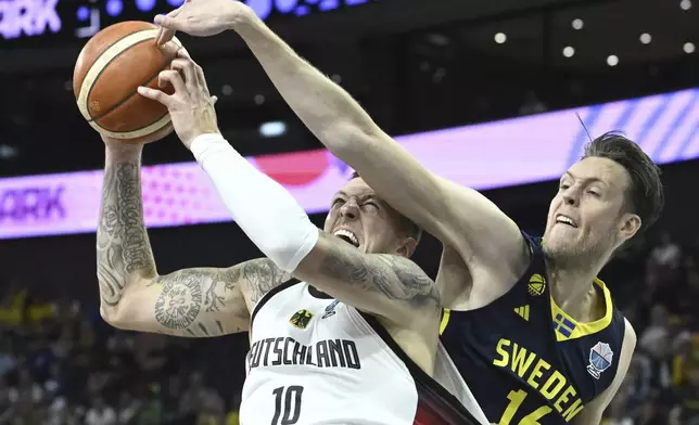 Germany's Daniel Theis, left, and Sweden's Nicholas Spires during Eurobasket, European Basketball Championship group B match between Germany and Sweden in Tampere, Finland, Friday, Aug. 29, 2025. (Heikki Saukkomaa/Lehtikuva via AP)